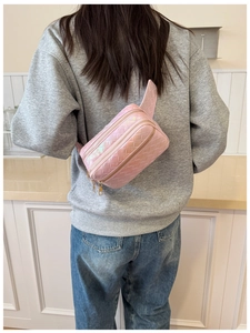 Sac banane rose irisé avec texture tressée et double fermeture éclair sur un mannequin