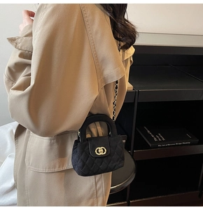 Detail of quilted black velvet girls handbag with gold chain strap and ring clasp