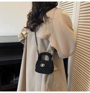 Detail of black quilted velvet mini bag with gold chain strap and dual-use handle