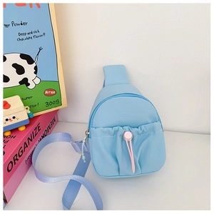 Detail of light blue kids crossbody bag with decorative pink drawstring and nylon texture