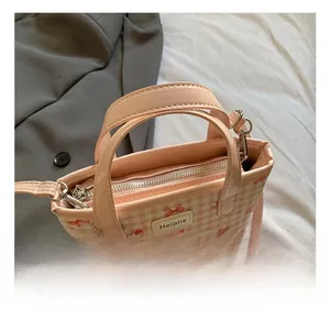 Sac seau rose à carreaux avec motif nœud rouge et détail de charme cœur
