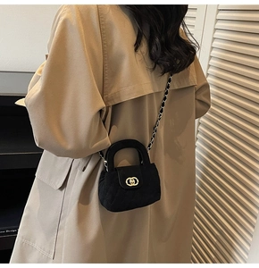 Mini black velvet quilted chain bag for girls styled on a child model wearing a trench coat