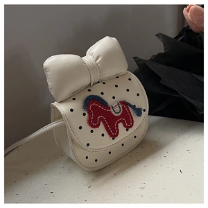 Détail d'un mini sac bandoulière à pois avec un grand nœud et une broderie cheval
