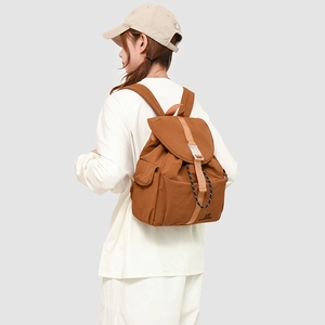 Caramel brown nylon backpack on model showing drawstring flap and side pockets