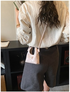 Fille portant un mini sac bandoulière rose avec motif cœurs et détail chien 3D