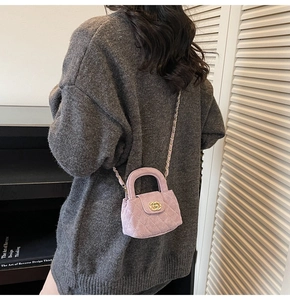 Pink quilted suede mini bag shown on model with light gold metal chain strap