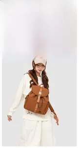 Close-up of caramel canvas backpack showing leather buckles and drawstring closure