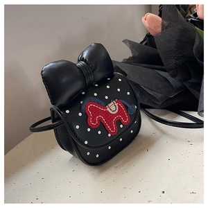 Détail du mini sac à bandoulière noir à pois avec un grand nœud et broderie de cheval