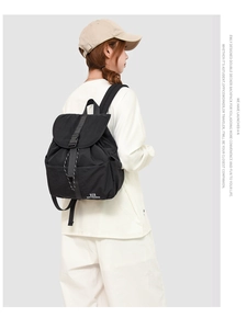 Detail of black school backpack with flap buckle closure and elastic side pocket