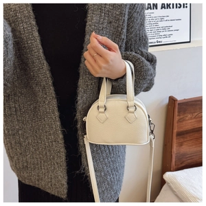 Detail of white lychee texture mini bowling handbag with zipper and leather strap