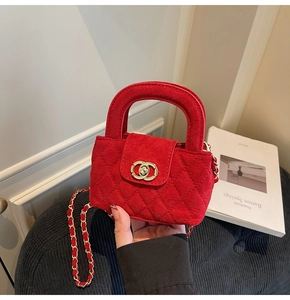 Detail of red quilted velvet mini bag with gold chain strap and interlocking metal clasp