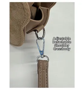 Detail of silver metal buckle on suede shoulder bag with detachable strap connector