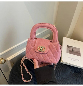 Close-up of pink quilted suede kids handbag with gold interlocking lock and chain strap