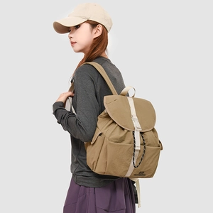 Detail of khaki drawstring backpack featuring nylon fabric and side water bottle pocket