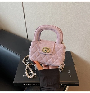 Close-up of pink velvet quilted handbag with gold chain strap and interlocking clasp