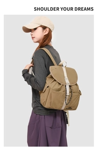 Detail view of khaki casual backpack with flap buckle and side pocket on a model