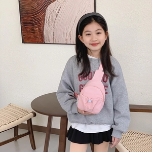 Minimalist pink kids chest bag with adjustable strap worn by a young girl on casual outfit