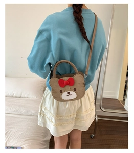 Brown cartoon bear crossbody bag shown on model to display size and fit