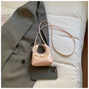 Detailed macro shot of pink mini crossbody bag with white lace trim and phone comparison