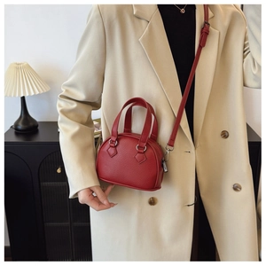 Close-up of red litchi grain leather mini shell bag with elegant silver hardware
