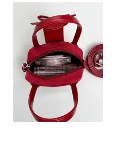 Vista interior del mini bolso rojo de piel con espacio para maquillaje y cremallera