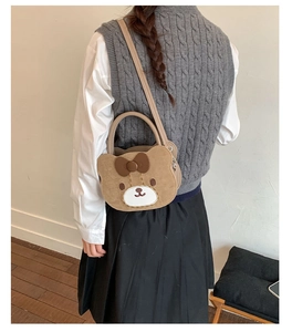 Detail view of brown bear-shaped crossbody bag worn by a model to show product scale