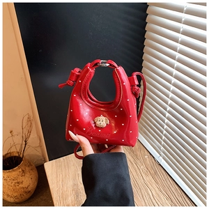Détail du mini sac à main rouge avec cœurs blancs, breloque ours et broderie Banna