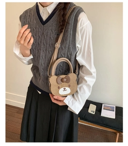 Detail of cute brown bear crossbody bag with bow decoration shown on a model