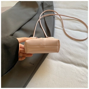 Close-up of pink leather kids handbag showing durable reinforced double stitching on bottom