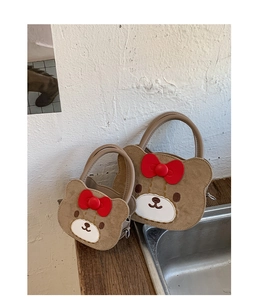 Detail of bear-shaped handbag set in brown suede with a red 3D bow and cute face design