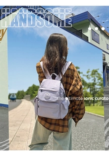 Détail du sac à dos lavande en tissu froissé avec logo KEMI et poche frontale