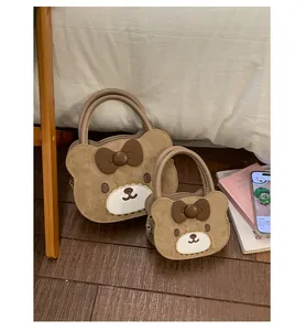Close-up of cute bear-shaped kids shoulder bags with 3D bows and soft suede texture