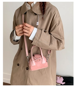 Detalle del mini bolso rosa con lazo decorativo y acabado en cuero mate de textura suave