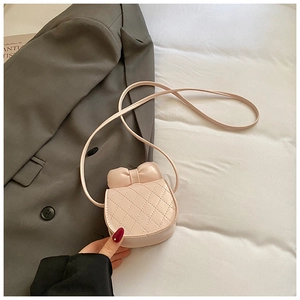 Détail d'un mini sac bandoulière rose pâle avec surpiqûres matelassées et nœud décoratif