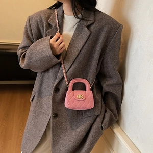 Pink quilted mini crossbody bag with gold chain strap shown on a tweed jacket