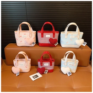 Vue détaillée des mini sacs seaux à carreaux avec breloques coeur en rose, rouge et bleu