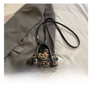 Détail du mini sac léopard avec poignée en cuir et bandoulière réglable pour enfant