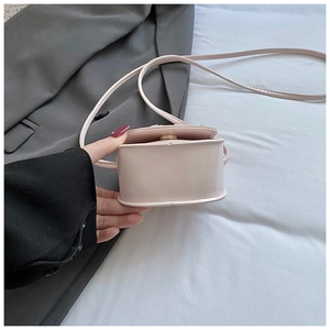 Vue détaillée du mini sac à bandoulière en cuir rose avec fermeture aimantée et coutures soignées