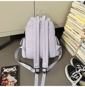 Vue arrière du sac à dos en nylon violet clair avec bretelles réglables et poches latérales