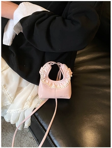 Detail of pink PU mini bag with white lace ruffle edges and HELAHE embossed logo