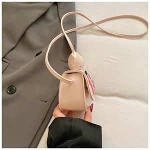 Vue latérale du sac bandoulière rose en cuir pour enfant avec poney et nœud peluche