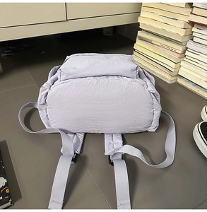 Vue détaillée des bretelles réglables et de la base du sac à dos en nylon violet clair