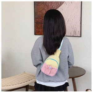 Détail du mini sac de poitrine macaron avec poche à cordon porté par un enfant mannequin