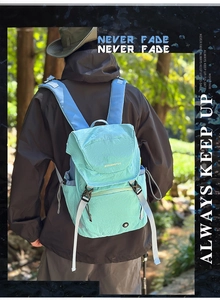 Detail eines mintgrünen Nylon-Rucksacks mit blauen Trägern und verstellbaren Seitentaschen
