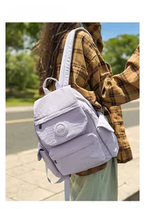 Photo en extérieur d'un sac à dos en nylon imperméable violet clair porté au dos
