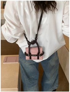 Détail du mini sac léopard en daim rose et cuir marron porté par un mannequin