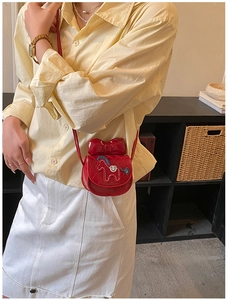 Détail du mini sac bandoulière matelassé rouge avec broderie poney et nœud