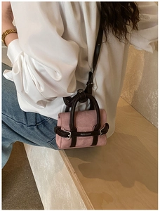 Détail du mini sac bandoulière en toile rose et cuir marron avec boucle en métal et poignées