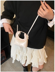 Detail of cream shoulder bag with pink lace trim and HEIAEE logo on PU leather