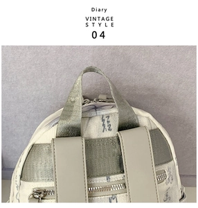 Detail of vintage canvas backpack with butterfly print, leather straps and metal zippers